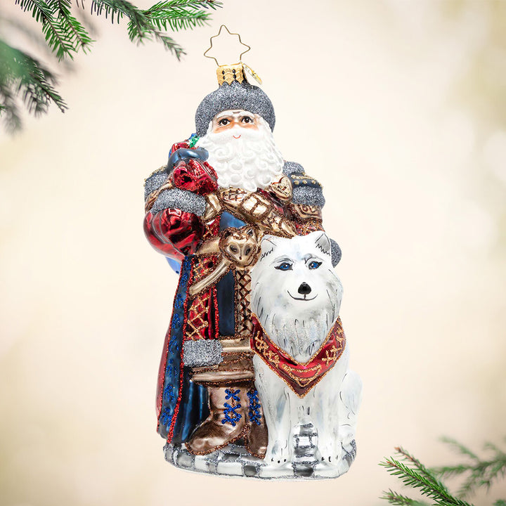 Northern Nicholas. Santa ornament of him next to a white wolf and dressed in a blue and red robe with silver and brown detailing. View of front