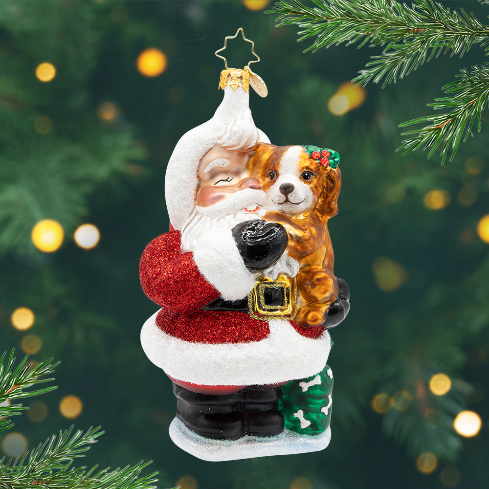 Jolly & Pawsome. Ornament of Santa in his classic red suit holding a brown dog. View of front.