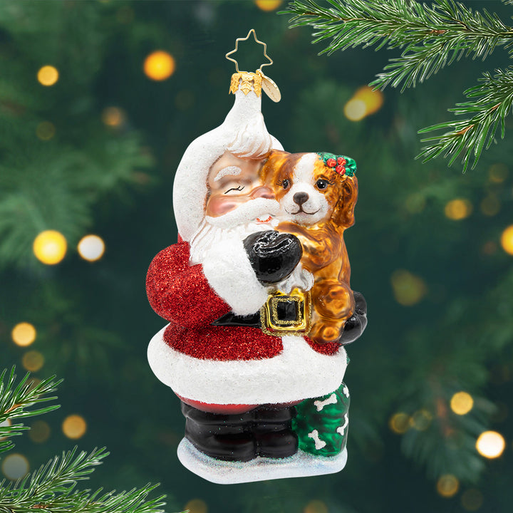 Jolly & Pawsome. Ornament of Santa in his classic red suit holding a brown dog. View of front.