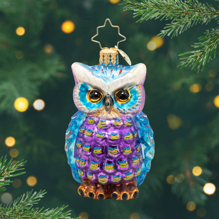 Regal Feathered Friend Gem. Ornament of a Blue and purple owl with glitter detailing's in blue and gold. View of front.