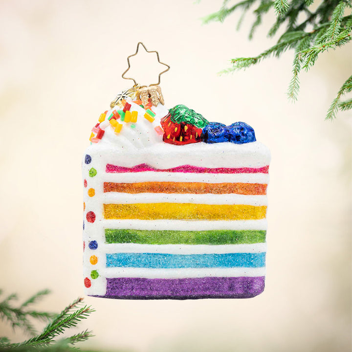 Slice Of Joy Gem. Ornament of a cake slice with rainbow stripes and sprinkles. View of front