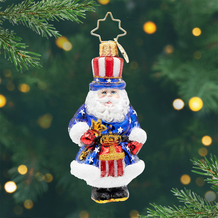 All-American Santa Gem. Santa ornament dressed in a blue robe with white stars and a matching red and white stripped hat. View of front.