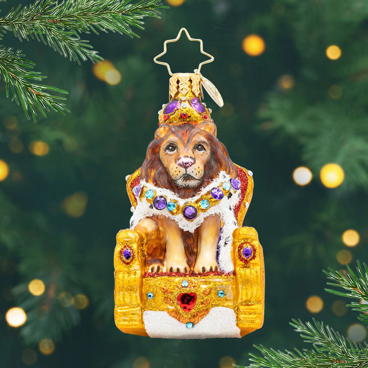 Regal Lion Majesty Gem. Ornament of a crowned lion sitting on a golden thrown purple gems. View of front