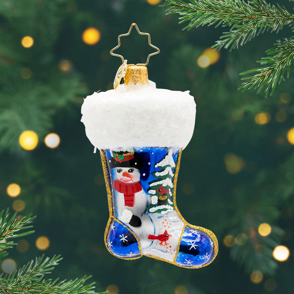 Winter Wishes Stocking Gem. Ornament of a blue stocking with a snowman painted next to a tree and two red cardinals.