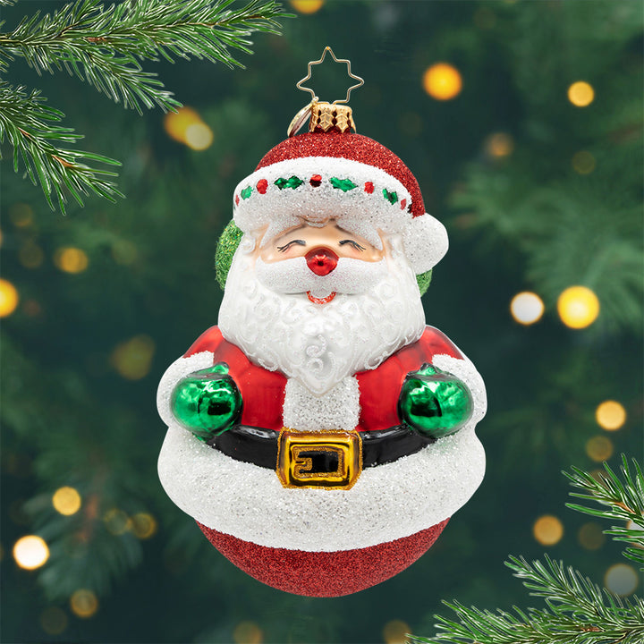 Double the Cheer. Ornament of Santa in his red suit and a round, red, sparkly base. View of front