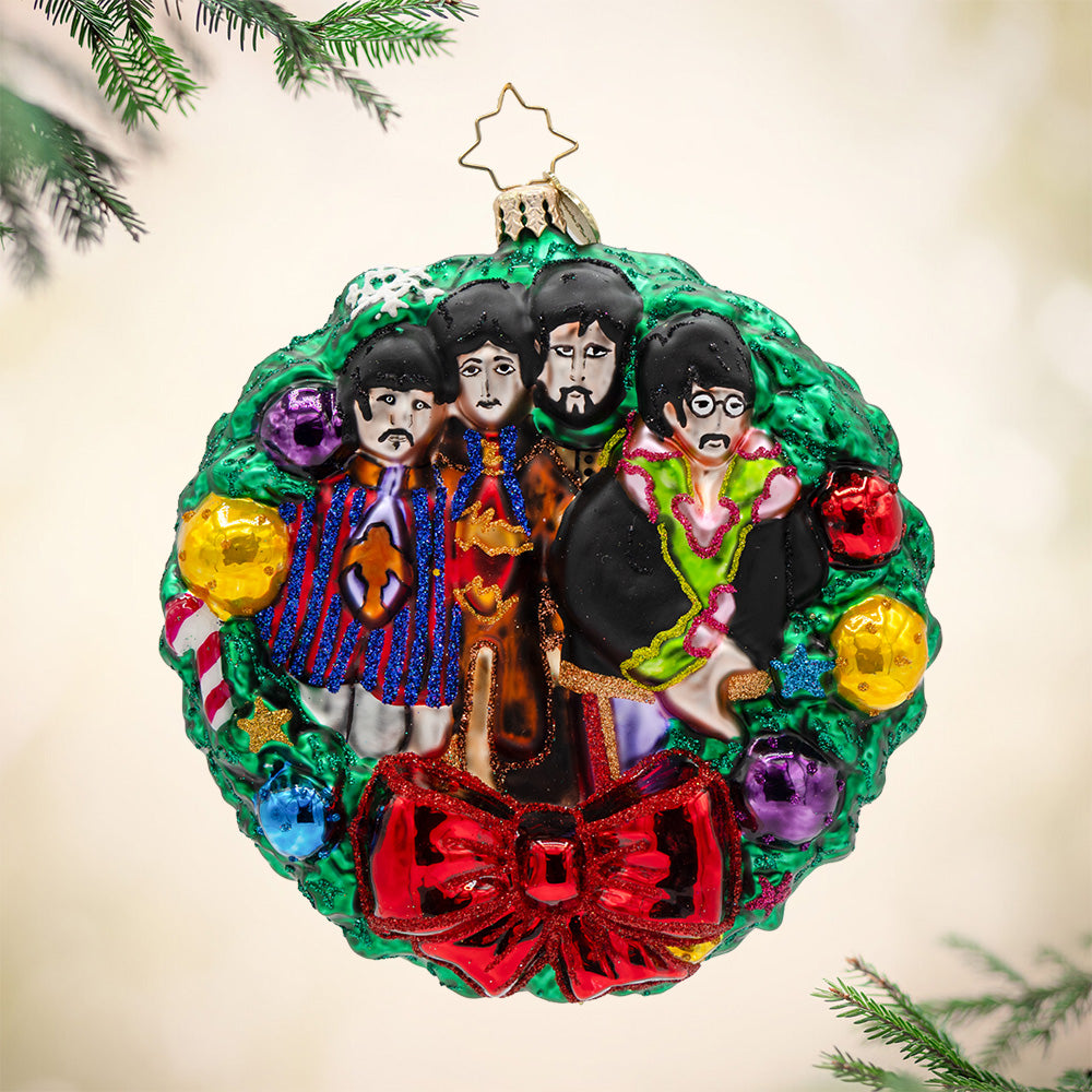 All You Need Is This Wreath. Ornament of the four members of the Beatles in a decorated Christmas wreath with a red bow. View of front