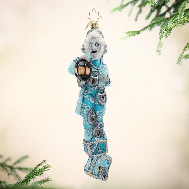 Snowy and the Cardinals Gem. Ornament of Jacob Marley in q blue suit while wrapped in silver chains and holding a lantern. View of front.