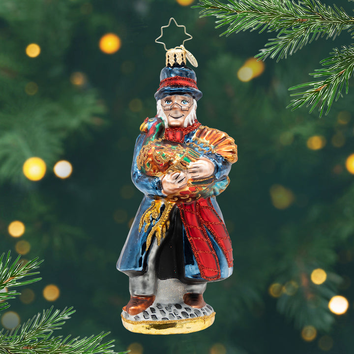 A Turkey for Tiny Tim. An ornament of Mr. Scrooge in a blue coat and holding a golden turkey. View of front.