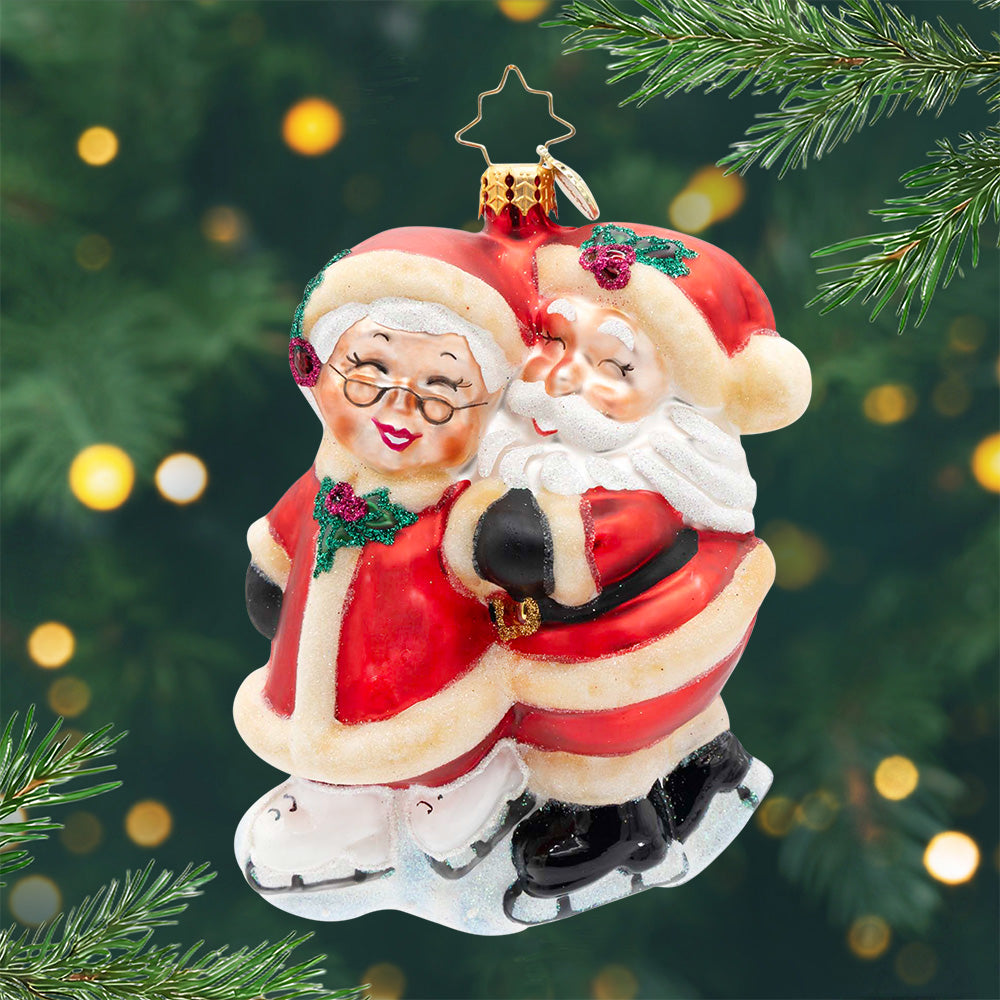 Skating into Christmas. Ornament of Mr. and Mrs. Clause in their classic red suits  skating together. View of front