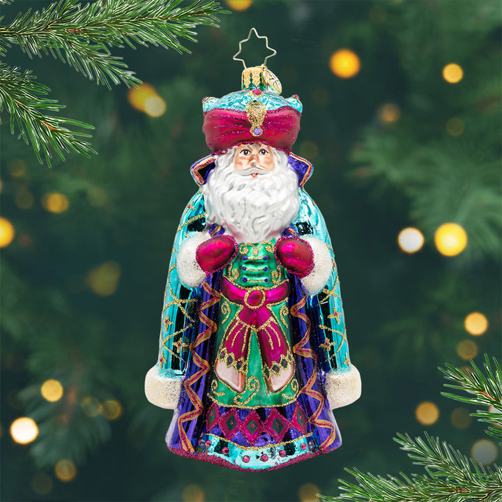 The Sultan of Christmas. Ornament of Santa wearing a blue and teal gem colored robe and turban with fine glitter patterns and gems. View of front