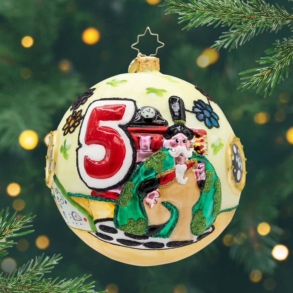 A Very Beatles Christmas.  A round ornament in a pastel yellow with a big red five and a 70's styled Santa. 