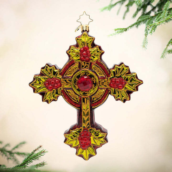 Evergreen Faith. Ornament of a cross adorned in gold, red, and yellow details. with red gems. View of front