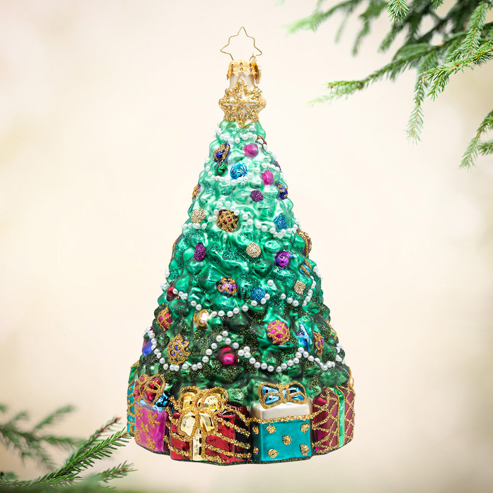 Victorian Splendor. A decorated Christmas tree in a green ombre with white pearl beads and sparkly ornament in purple, blue, and pink, and a base full of colorful presents. View of front
