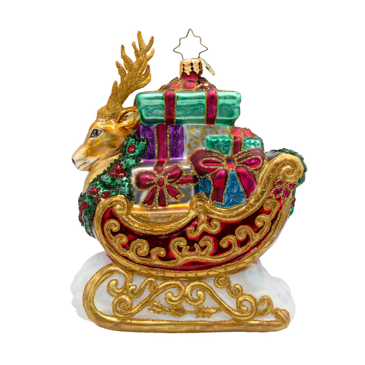The Noble Sleighride. Ornament of Santa's red and golden sleigh with part of a reindeer in the front and many different colored presents inside. View of front.