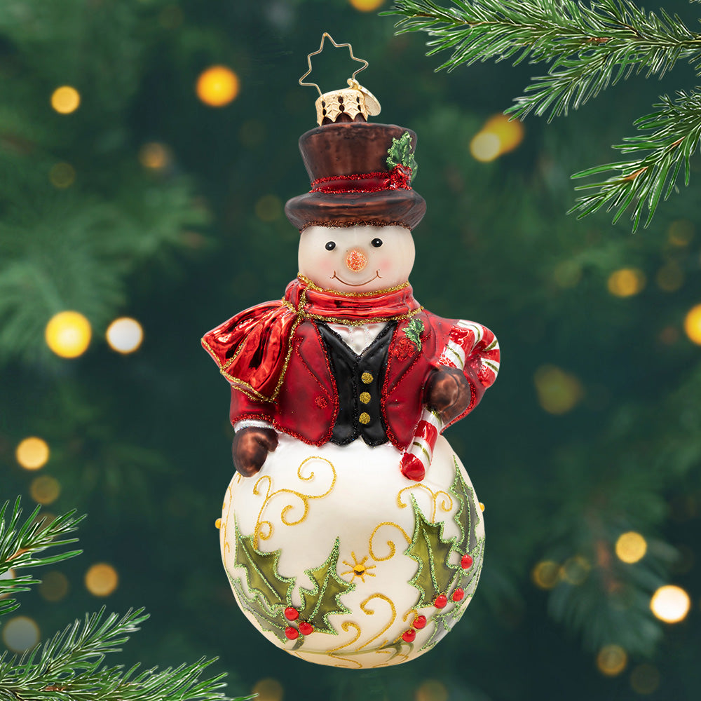 The Jingle Gent. A snowman ornament dressed in a red tailored top coat and hat with a decorated base of two green mistletoes. View of front