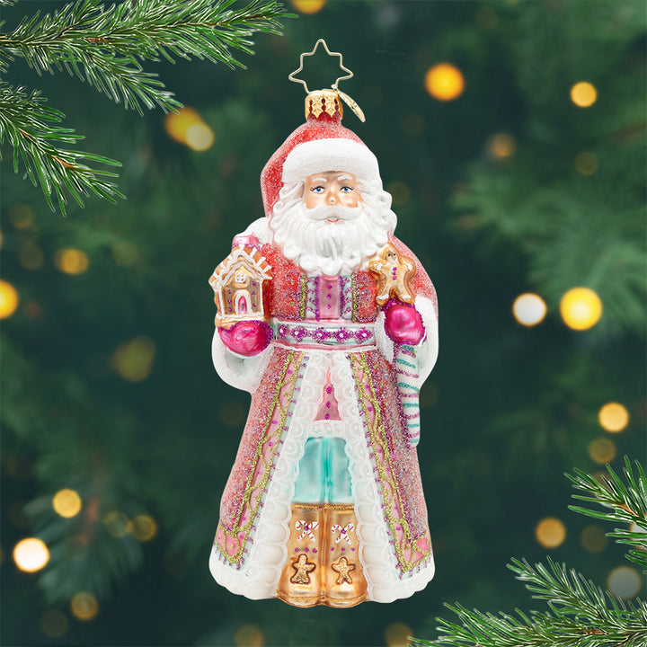 The Claus Confection. This ornament of Santa is dressed in a vibrant pink and purple with hints of gold and teal. View of front