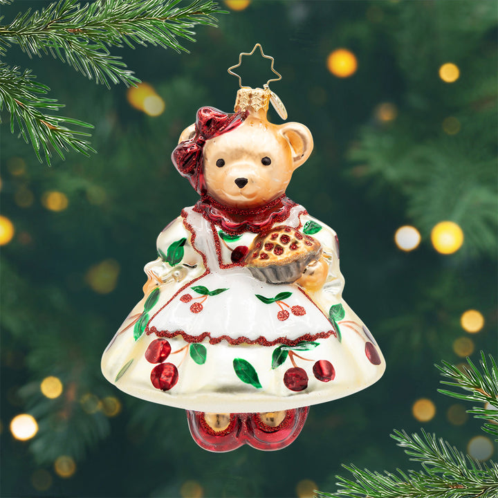 Muffy's Slice of Sweetness. A bear ornament, dressed up in a white dress with cherries and holding a cherry pie. View of front