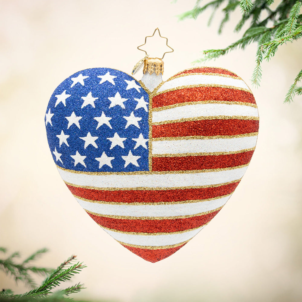 Heart of Independence – 250 Years. A heart shaped ornament with a sparkly American flag on the front. View of front