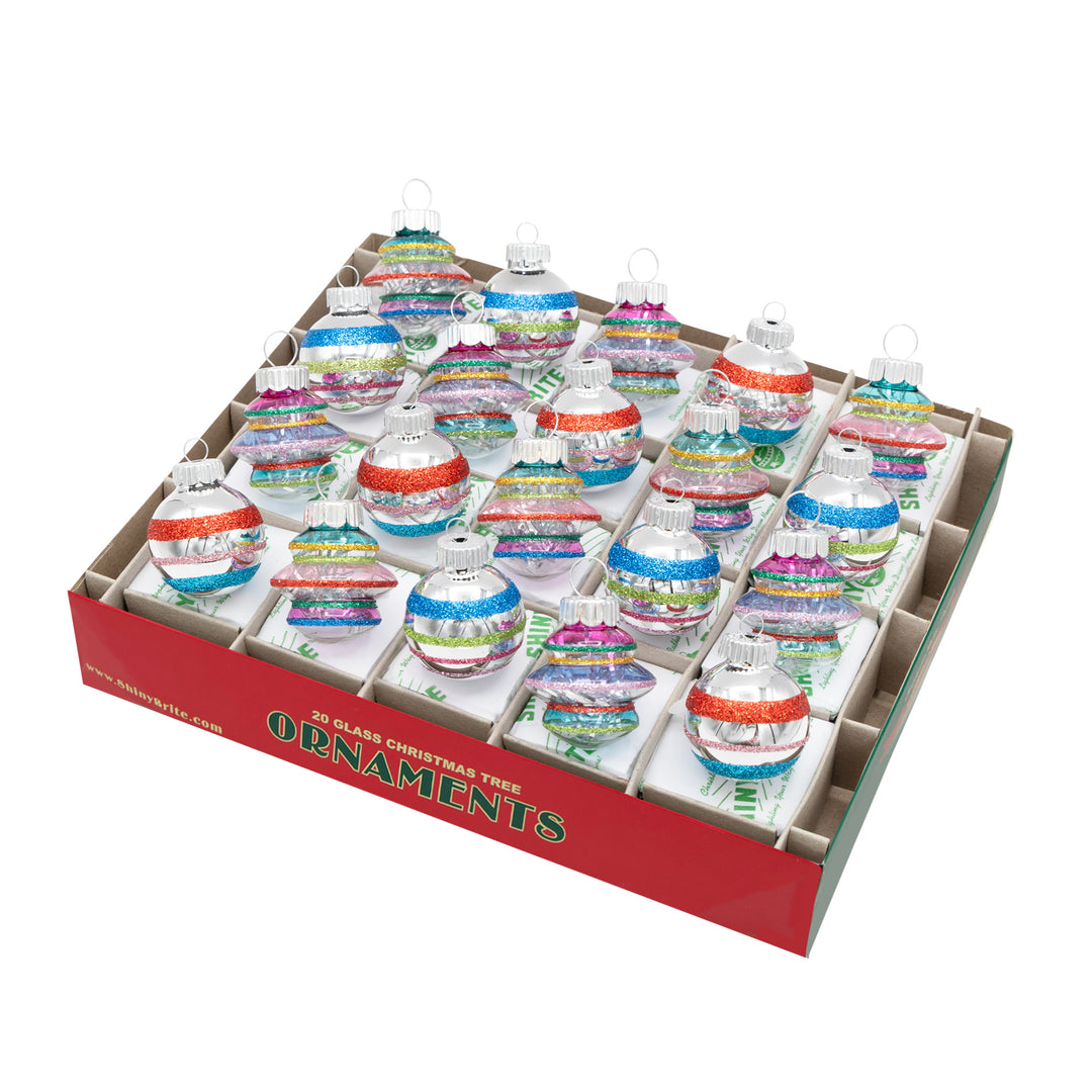  CHRISTMAS CONFETTI 20 COUNT 1.25" SHAPES & ROUNDS. Ten teardrop ornaments that are transparent with silver tinsel inside and colored with red, purple, pink, green, yellow, and blue stripes, and ten round ornaments that are silver with the same-colored stripes.