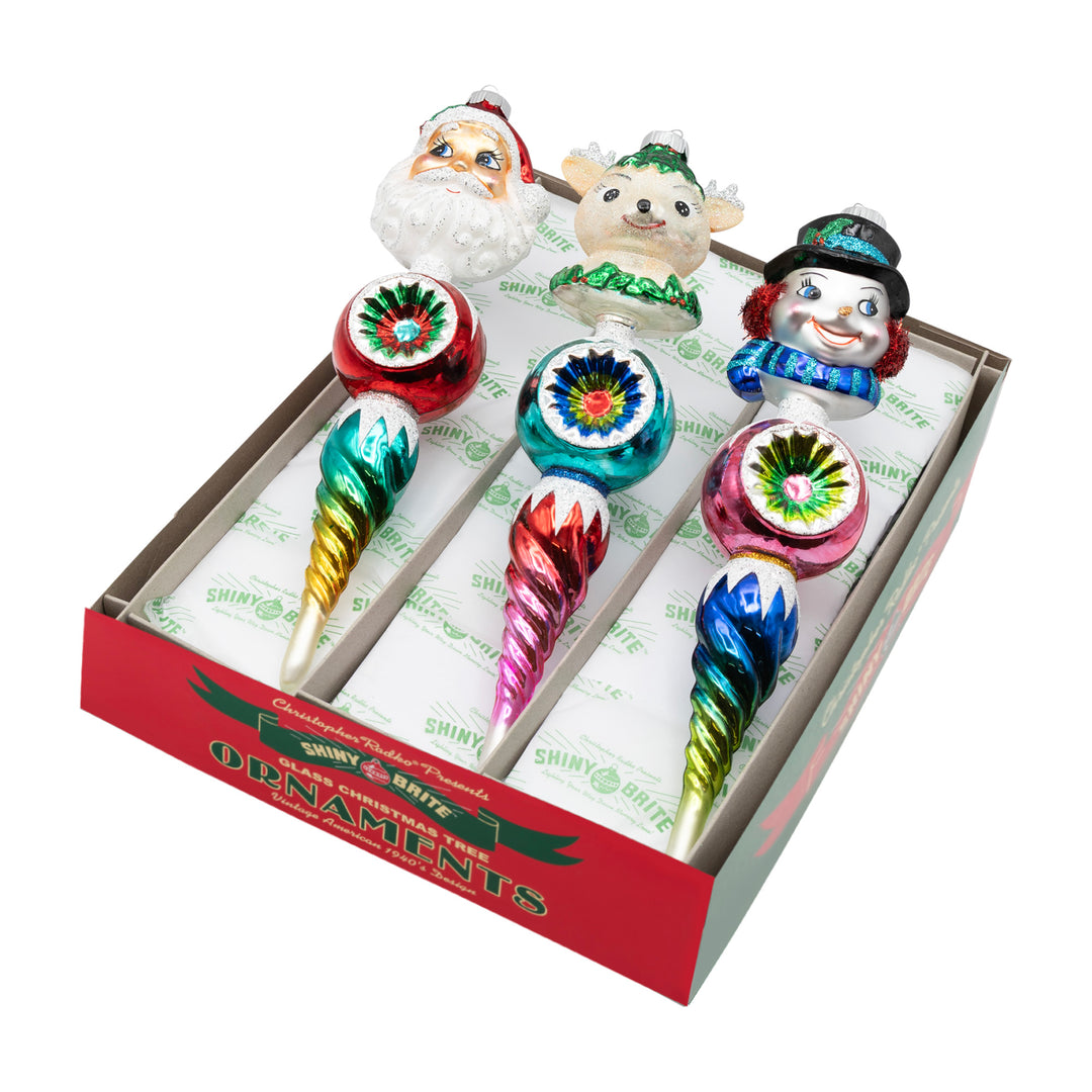 CHRISTMAS CONFETTI 3 COUNT 10.5" FIGURE ROUNDS. Three icicle ornaments with colored in red, green, blue, and pink ombré, along with each having a different figure's head of either Santa, a snowman, or a reindeer.