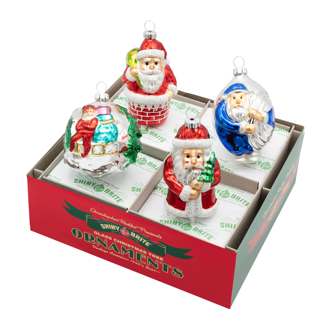 CHRISTMAS CONFETTI 4 COUNT 3.25"  SANTA FIGURES. Two round ornaments, one with Santa and a bag of presents and the other of Santa dressed in blue carrying a bag. Two other ornaments, one in the shape of Santa and the other of Santa going down a chimney.