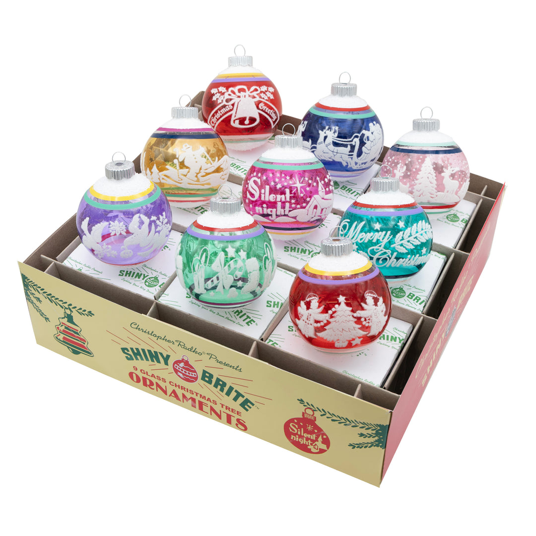 VIVID VINTAGE 9 COUNT 2.5" SIGNATURE FLOCKED ROUNDS. Nine round, transparent colored red, pink, blue, green, purple, green, and yellow ornaments each with a unique design painted in white.
