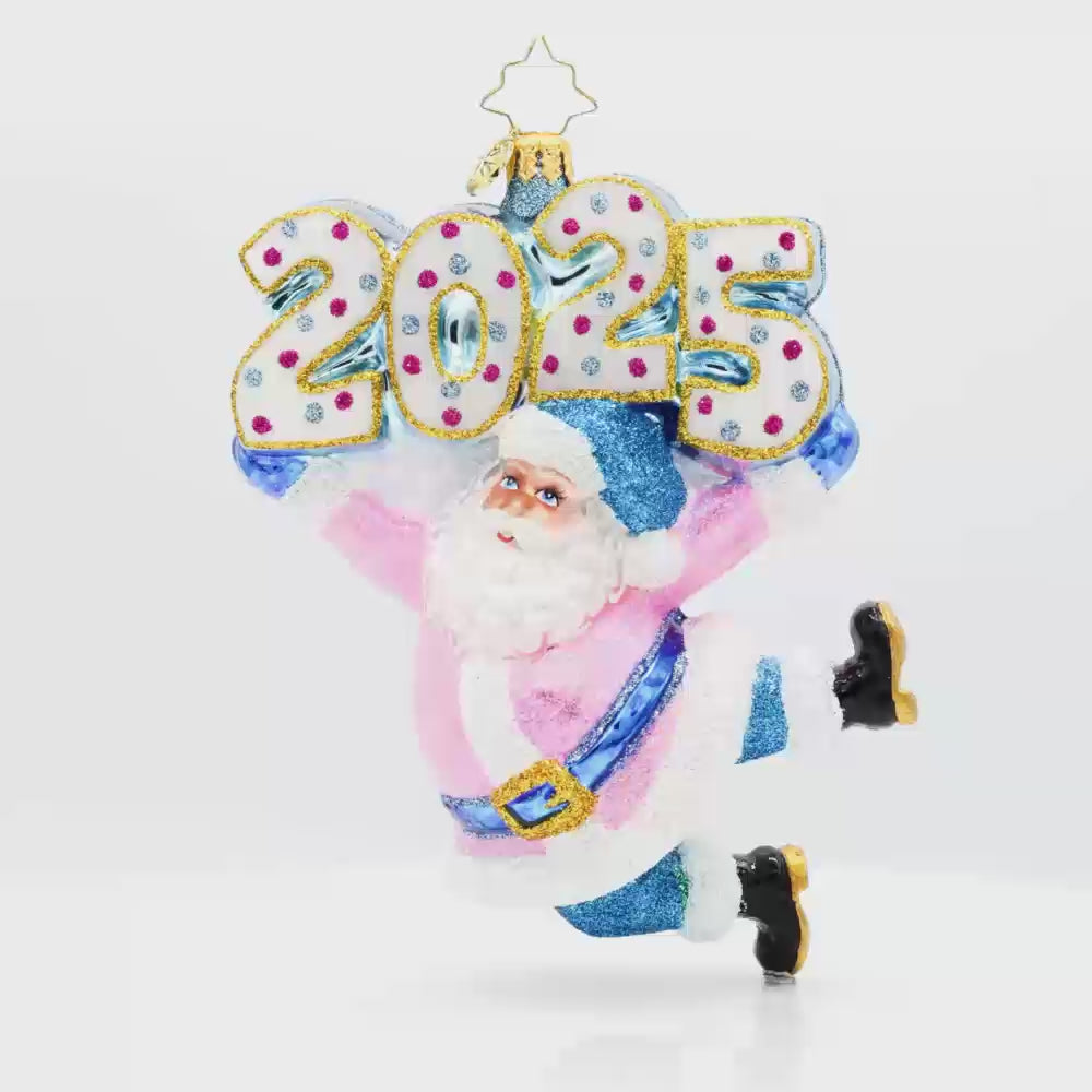 Jingle Bell Jamboree Ornament. Santa's rocking a dazzling outfit with glittering accents and a splash of pink. "2025" is held above his head in similar colors. Video