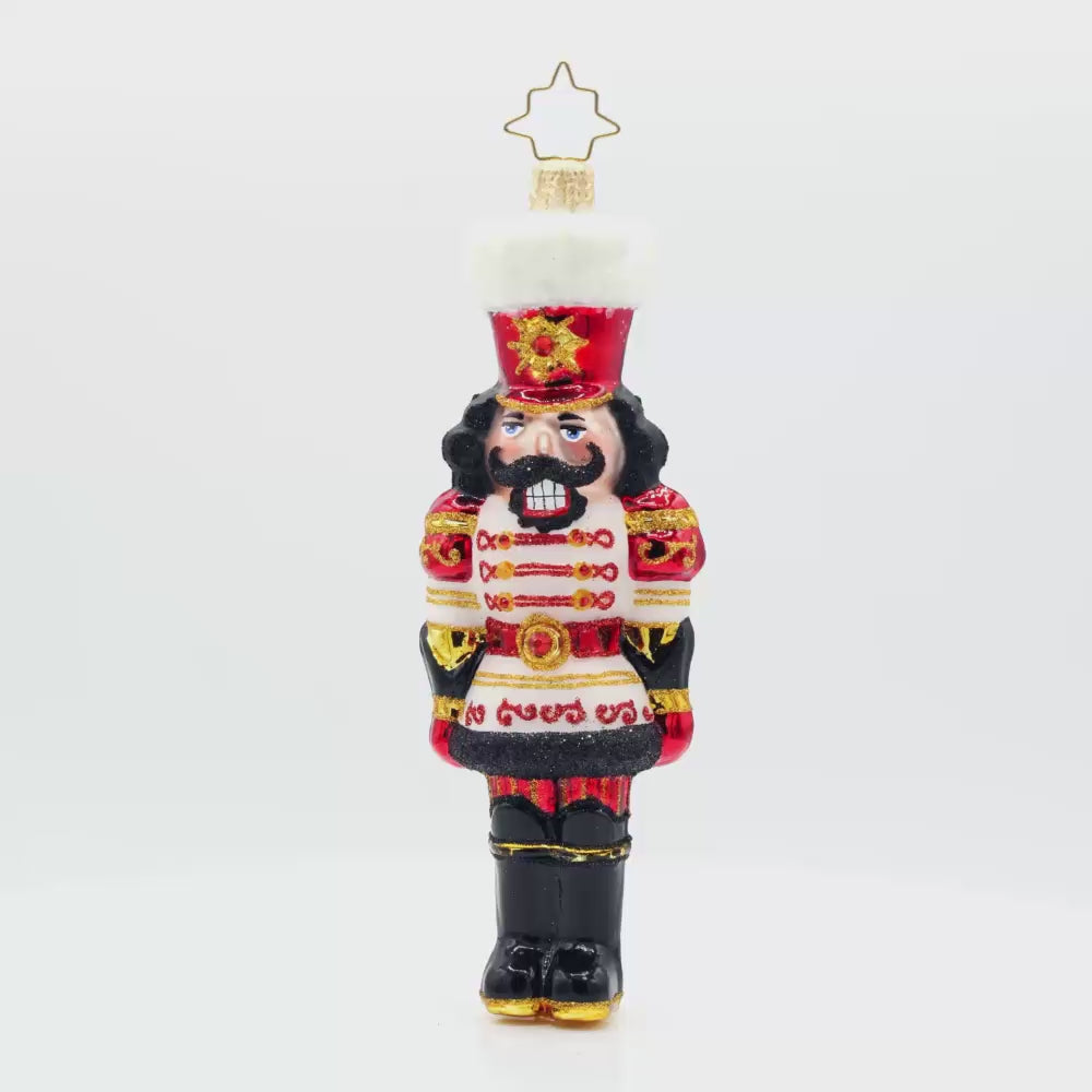 Gemstone Guardian ornament. This nutcracker wears a satin white jacket adorned with red gems and shiny black boots. Video.