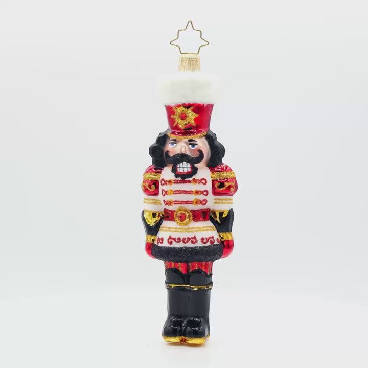 Gemstone Guardian ornament. This nutcracker wears a satin white jacket adorned with red gems and shiny black boots. Video.