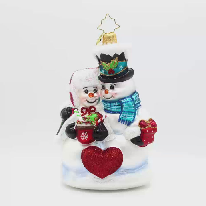 Winter Lovebirds ornament. A lady and gentleman snowman cuddle up with a cup of hot cocoa. Video.