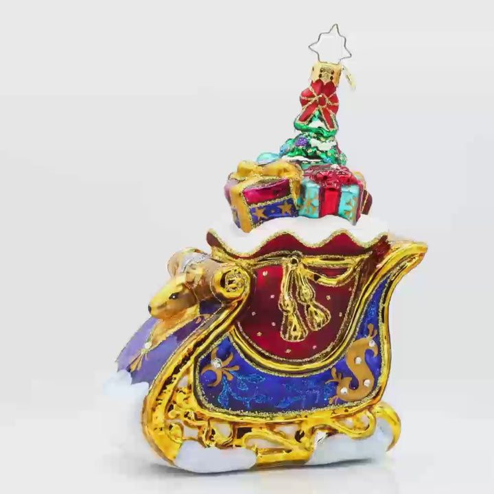 Celebratory Sleighride ornament. Royal Blue and gold sleigh, adorned with shimmering jewels and regal ribbons. Video.