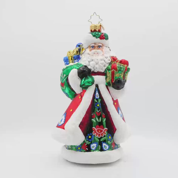 Folk Festive Claus ornament. Clad in a sumptuous dark green gown, adorned with a hand-painted folk pattern, this Santa celebrates the beauty of Polish heritage. Video.