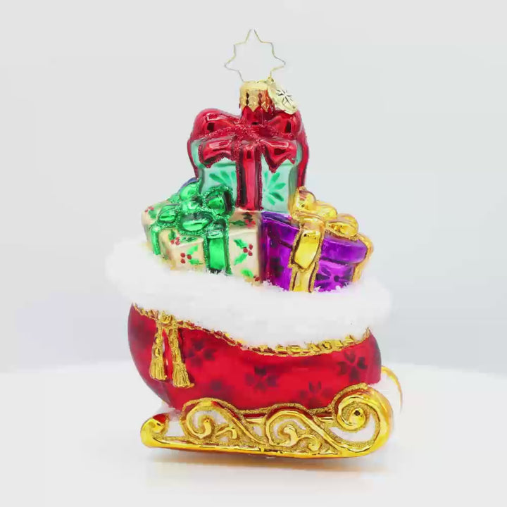 Sleighful of Wonders ornament. A bright red and gold sleigh is overflowing with gifts. Video.