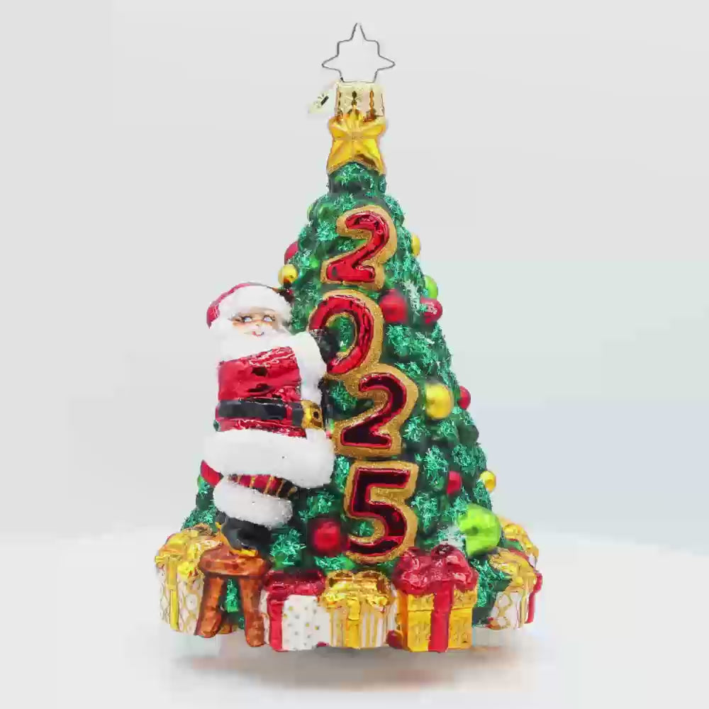 Santa's 2025 Tree Trim. Santa is seen decorating the Christmas tree with all the trimmings. Tree is dated with "2025." Video.