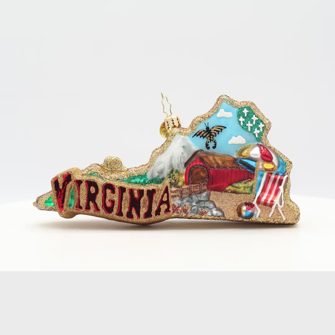 Front view ornament of mountains to sandy shores with the phrase "Virginia" with a cozy red barn, a butterfly, a beach chair, an umbrella, and beach ball. 