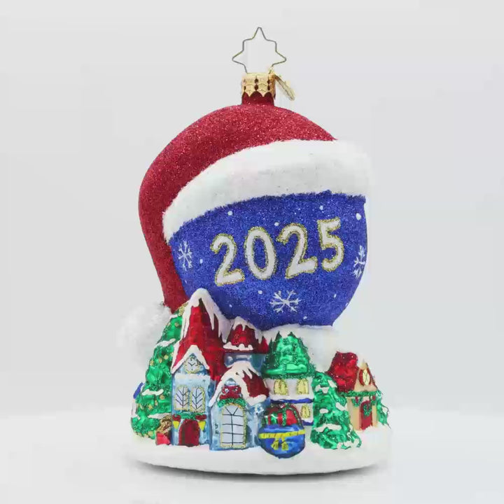 Twas the Night Before Moonlight ornament. Dressed in a Santa hat, this glowing moon dated with "2025" keeps a watchful eye on the Christmas village below. Video.
