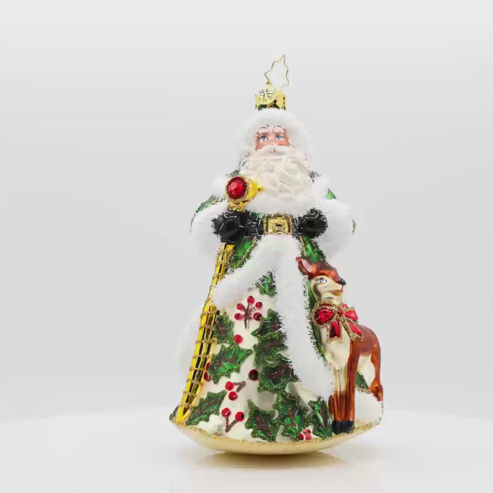 Deerly Beloved Santa ornament. Santa and his reindeer are dressed to impress. Santa dons a green hand-painted coat of holly. The reindeer has a red bow around its neck. Video.
