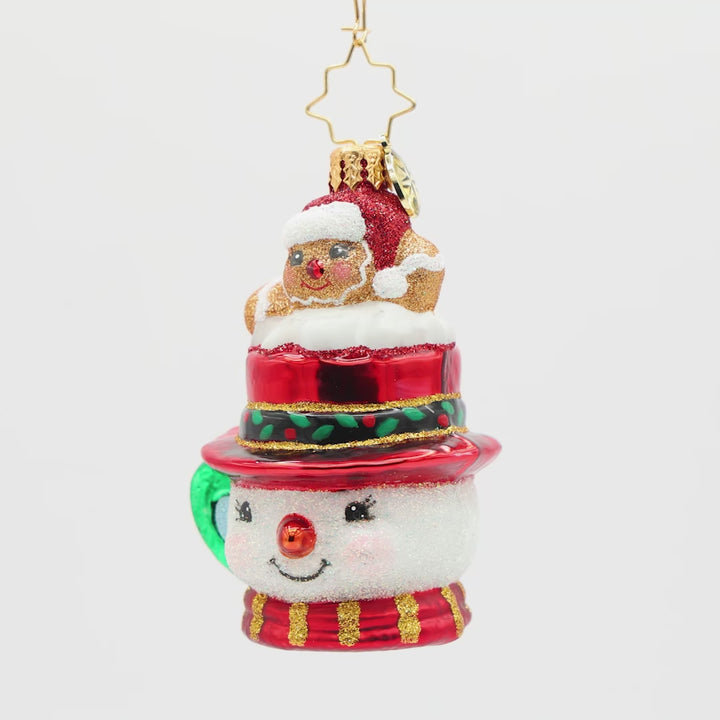Front view of a snowman ornament shaped like a mug with a  gingerbread man sitting on top of the hat design on a white background