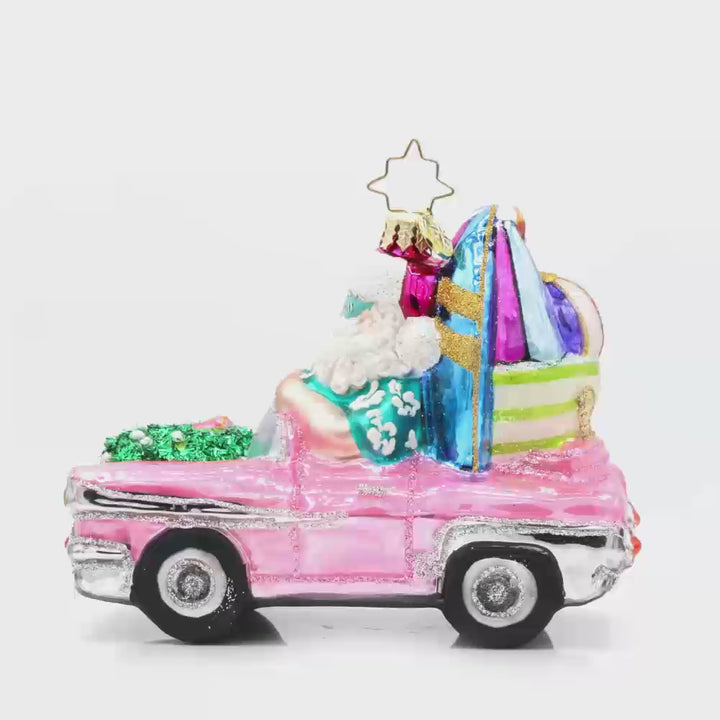 Santa's Coastal Christmas Ride ornament. Santa drives a pink car with his surfboard, sunglasses, and beach gear. Video.