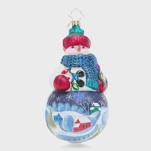 Video - Ornament Description - Winter's Snowy Scene: Mr. Snowman is dressed for the weather in his favorite wintertime accessories that allow him to show off the snow-covered countryside landscape painted on his belly. Bundle up, buddy! This video shows the ornament slowly spinning. 