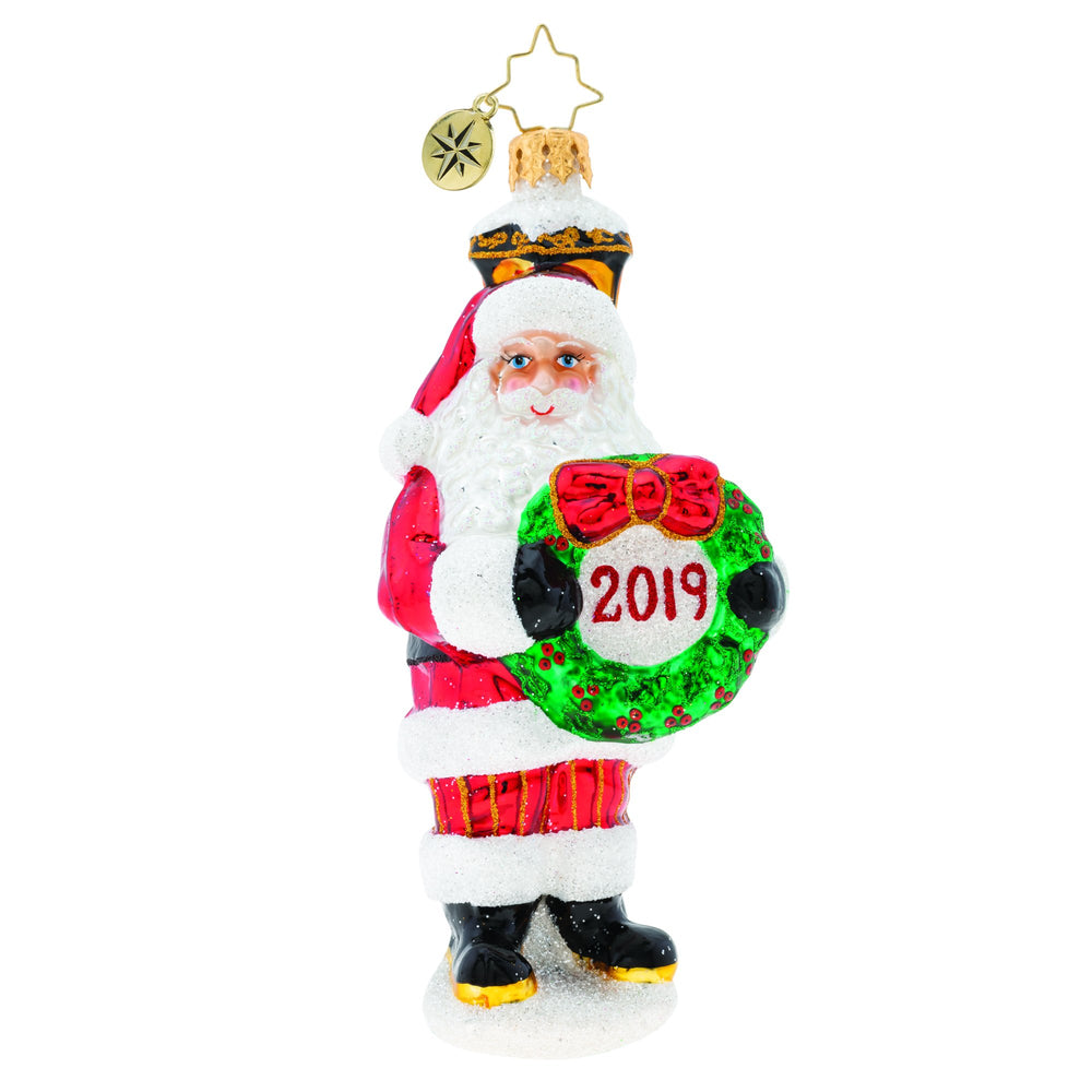 Ornament Description - Celebrate 2019 Snata!: Santa stands under a classic light post with a holly wreath surrounding the celebration of 2019! What a memorable keepsake for a grand 2019 year!