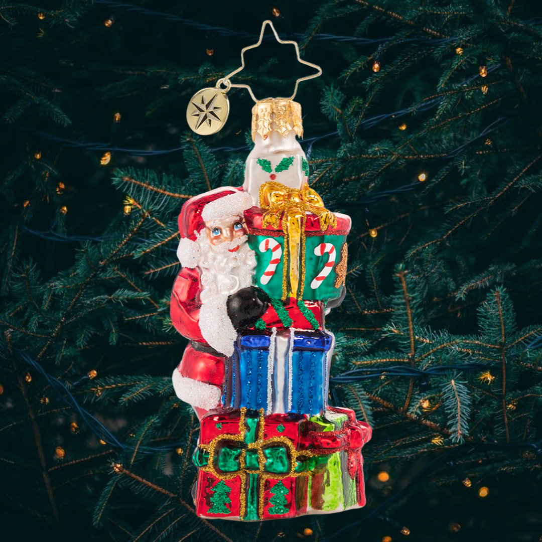 Ornament Description - A Tower of Tidings Gem: Santa sure has his hands full with all these gifts! Luckily after centuries of juggling Christmas responsibilities, he has become an expert at balance!