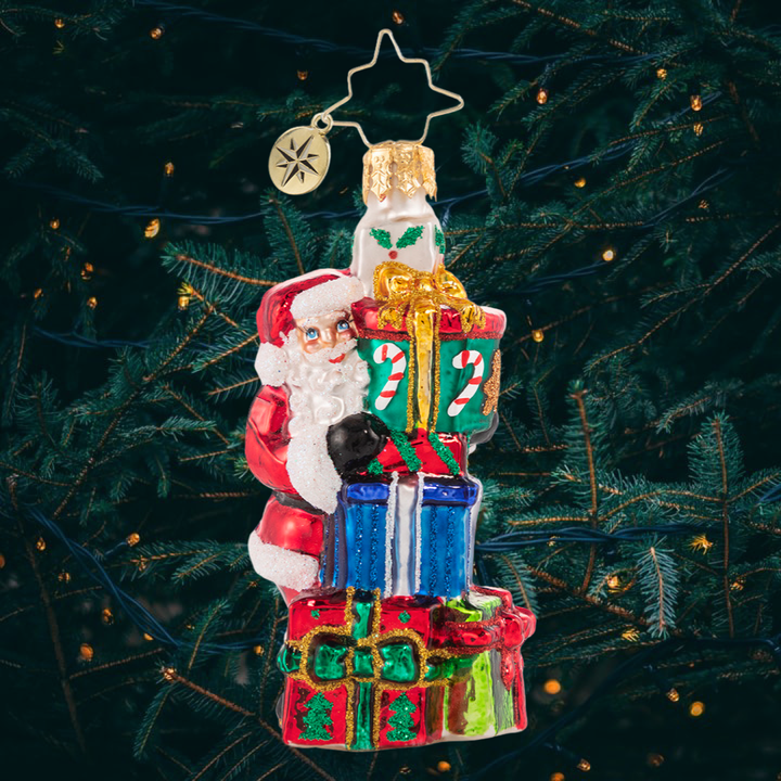 Ornament Description - A Tower of Tidings Gem: Santa sure has his hands full with all these gifts! Luckily after centuries of juggling Christmas responsibilities, he has become an expert at balance!