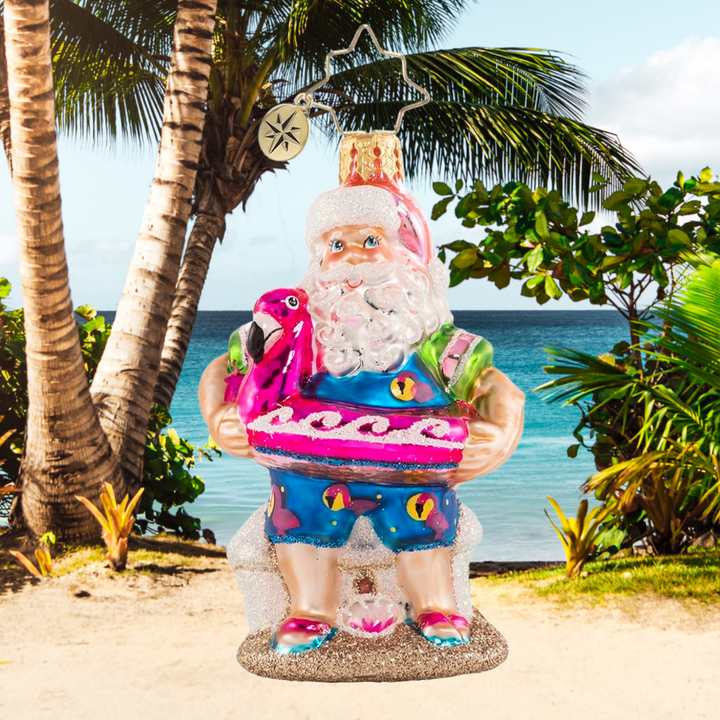 Ornament Description - Out of Office Santa Gem: After his jam-packed holiday season, Santa is relaxing on a well-deserved vacation! He has traded his fur suit for swim shorts and his sack for a flamingo floatie-- he is looking ready for some off-duty fun in the sun!
