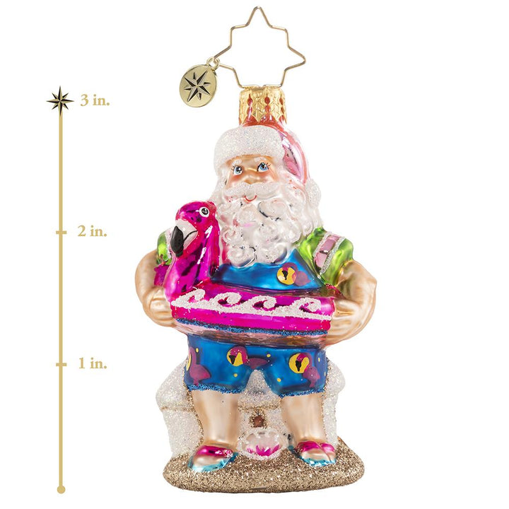 Ornament Description - Out of Office Santa Gem: After his jam-packed holiday season, Santa is relaxing on a well-deserved vacation! He has traded his fur suit for swim shorts and his sack for a flamingo floatie-- he is looking ready for some off-duty fun in the sun! This photo shows the ornament spinning slowly. 