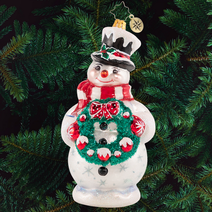 Ornament Description - Darling Christmas Decorator: Deck the halls! Wreath in hand, this sweet snowman is always first to volunteer for holiday decorating duty.