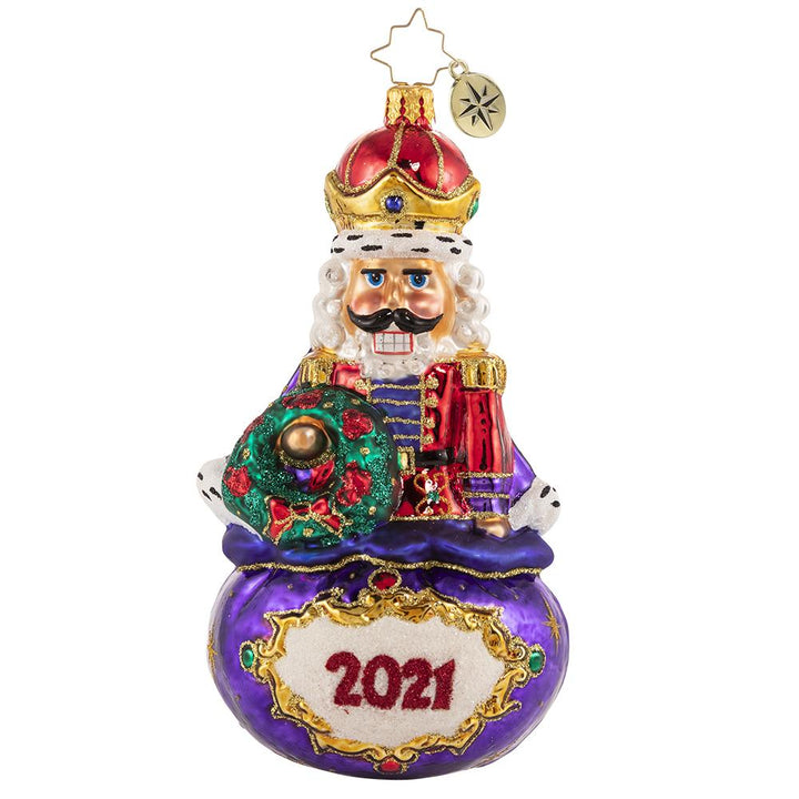 Front - Ornament Description - Imperial Icon Nutcracker 2021: Ever the dutiful servant, this noble nutcracker watches over Santa's sack of treasures. He takes his job seriously, but he cannot help 'cracking' a smile!