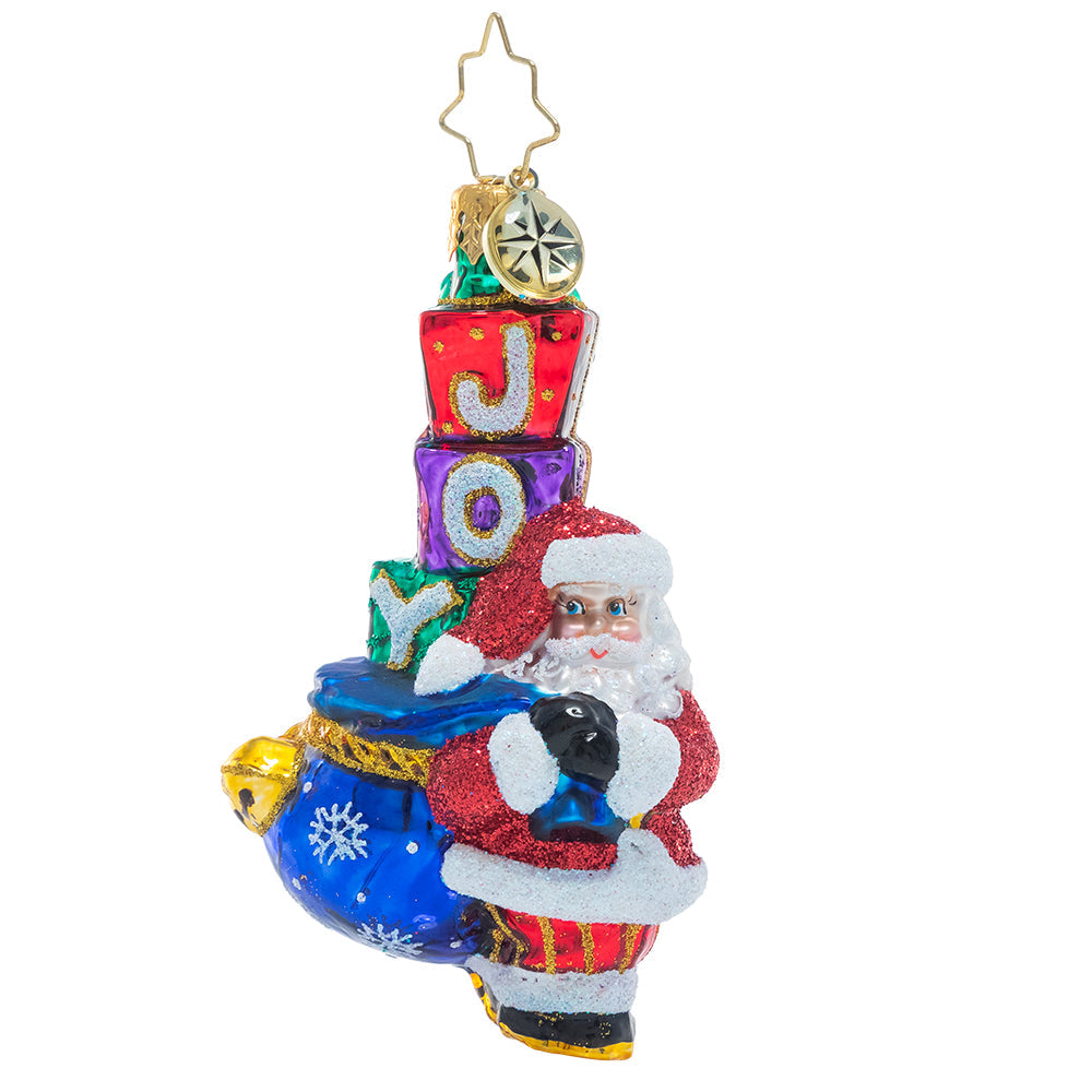 Front - Ornament Description - Joyous Saint Nick Gem: Santa's his name, and JOY is his game! Everyone's favorite elf carries a sack piled high with surprises, primed to spread Christmas cheer to one and all.