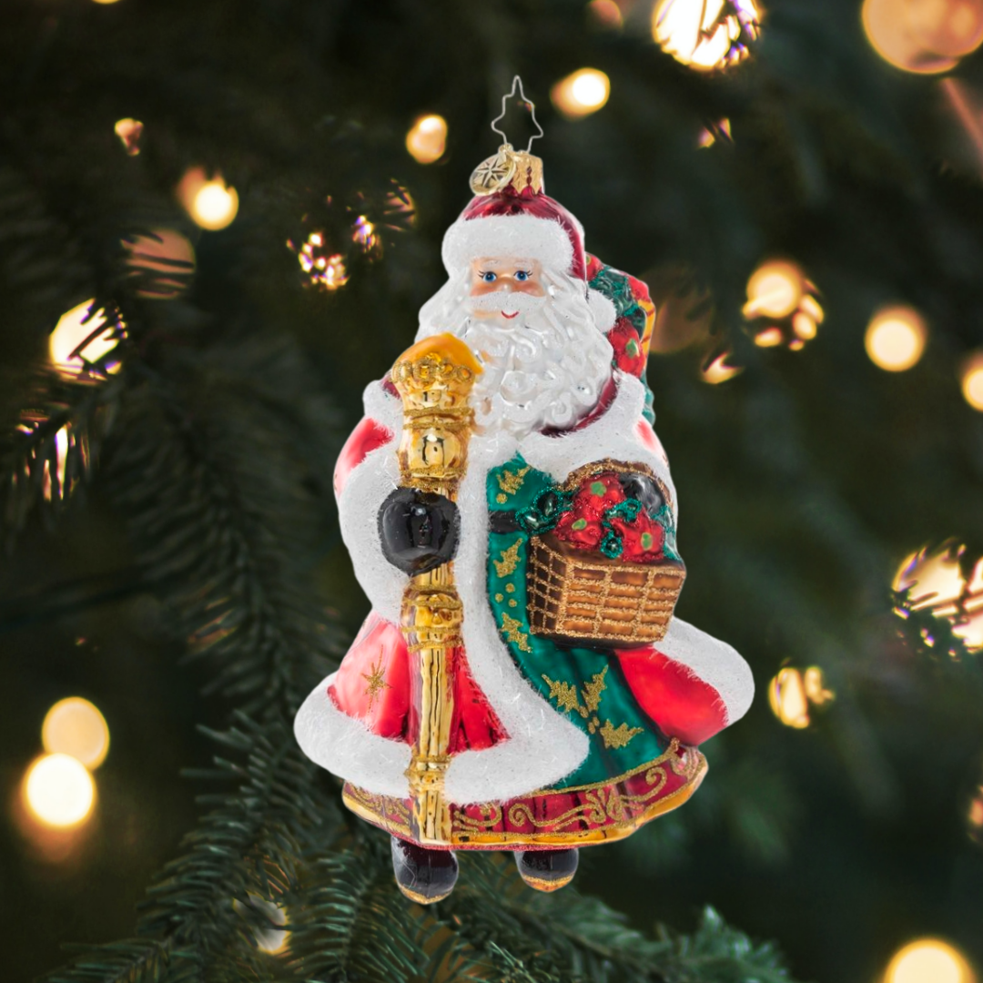 Ornament Description - Festive Florals Santa: With a gift basket of Christmas poinsettias and decorated robes to match, Santa is heading to a fancy holiday party. His golden staff will help light the way through the snow.