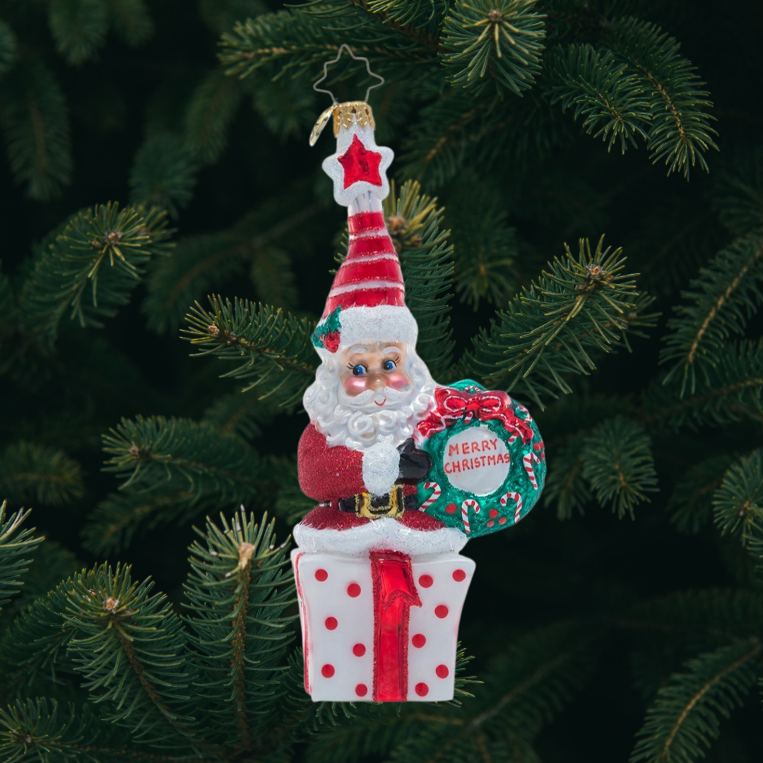Ornament Description - Vintage Vibrance: This cheery little Saint Nick wishes you a very Merry Christmas! Dressed in glittering ruby red and an extra-festive Santa cap, this jolly elf is ready to celebrate the season.